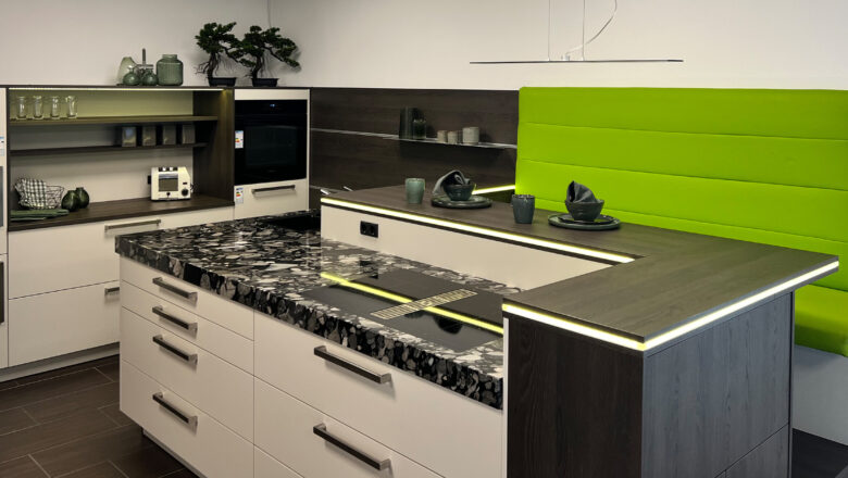 Inselküche mit Elementstein-Arbeitsplatte und grüner Sitzbank