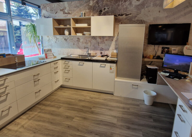 Weiße Hochglanz-Lack Küche in L-Form mit schwarzer Naturstein-Arbeitsplatte