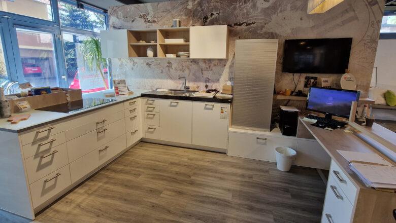 Weiße Hochglanz-Lack Küche in L-Form mit schwarzer Naturstein-Arbeitsplatte