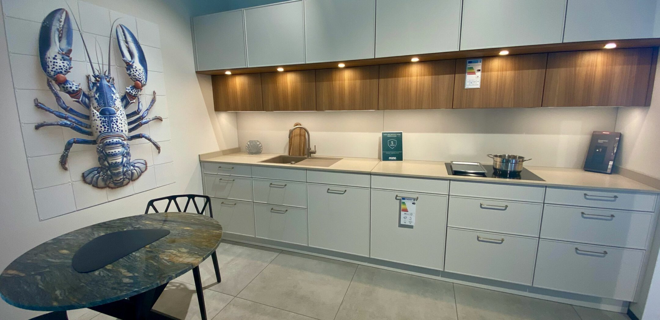 Helle Fronten, eine helle Arbeitsplatte und schmale Griffe prägen das Bild dieser zweizeiligen Küche