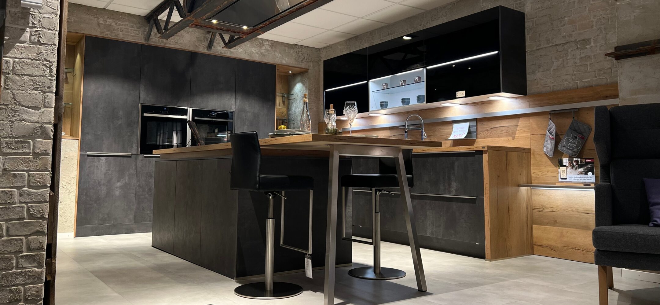 Untenaufnahme Inselküche in Steinoptik mit Holzarbeitsplatte bei PLANA in Ravensburg