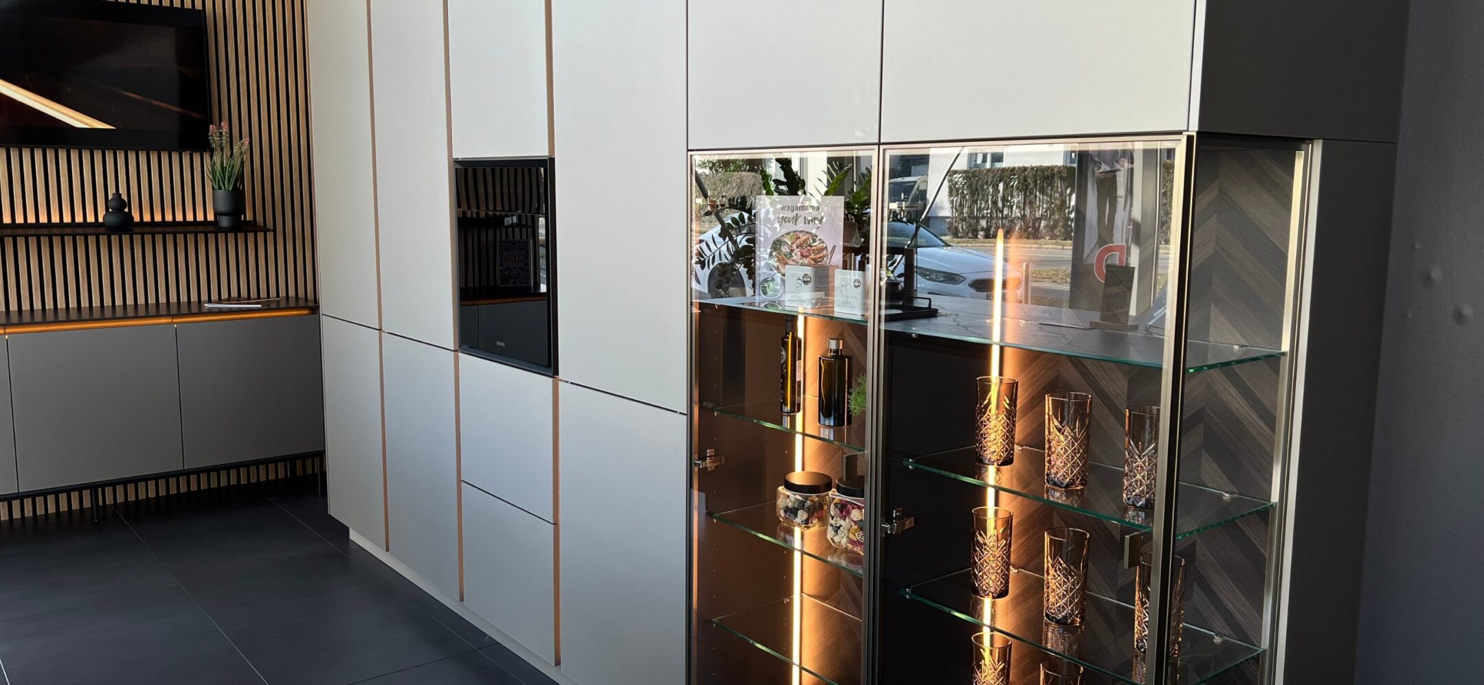 Grifflose weiße Küchenzeile mit integrierter Glasvitrine in der Küchenausstellung in Ravensburg