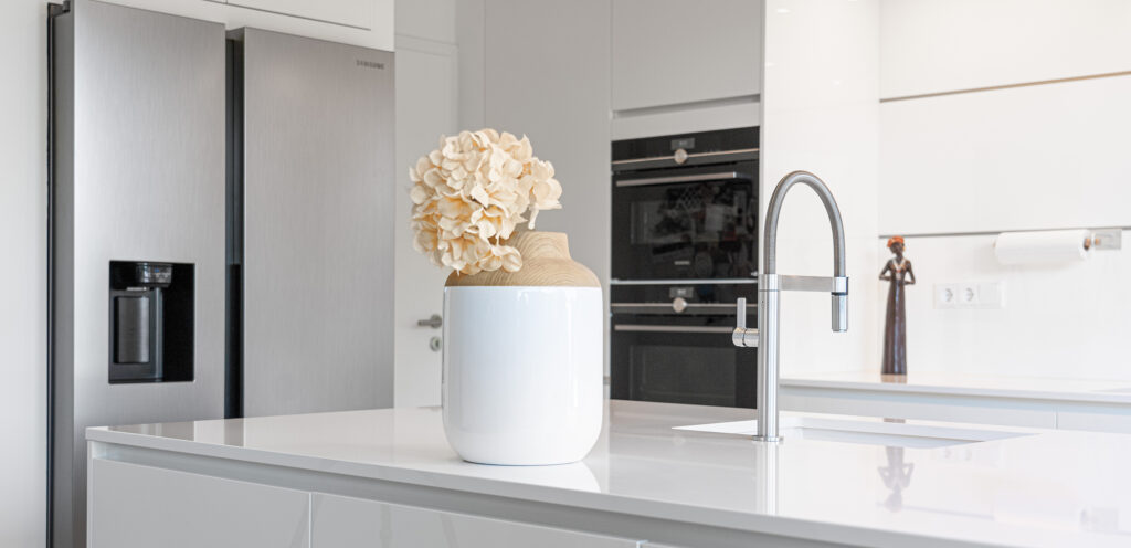 PLANA Küchenausstellung Germersheim moderne Inselküche mit weißen Fronten und heller Steinarbeitsplatte