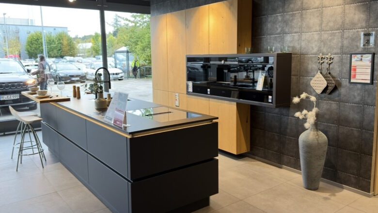 Grifflose Inselküche mit Fornten aus Echtholz und schwarzem Mattglas