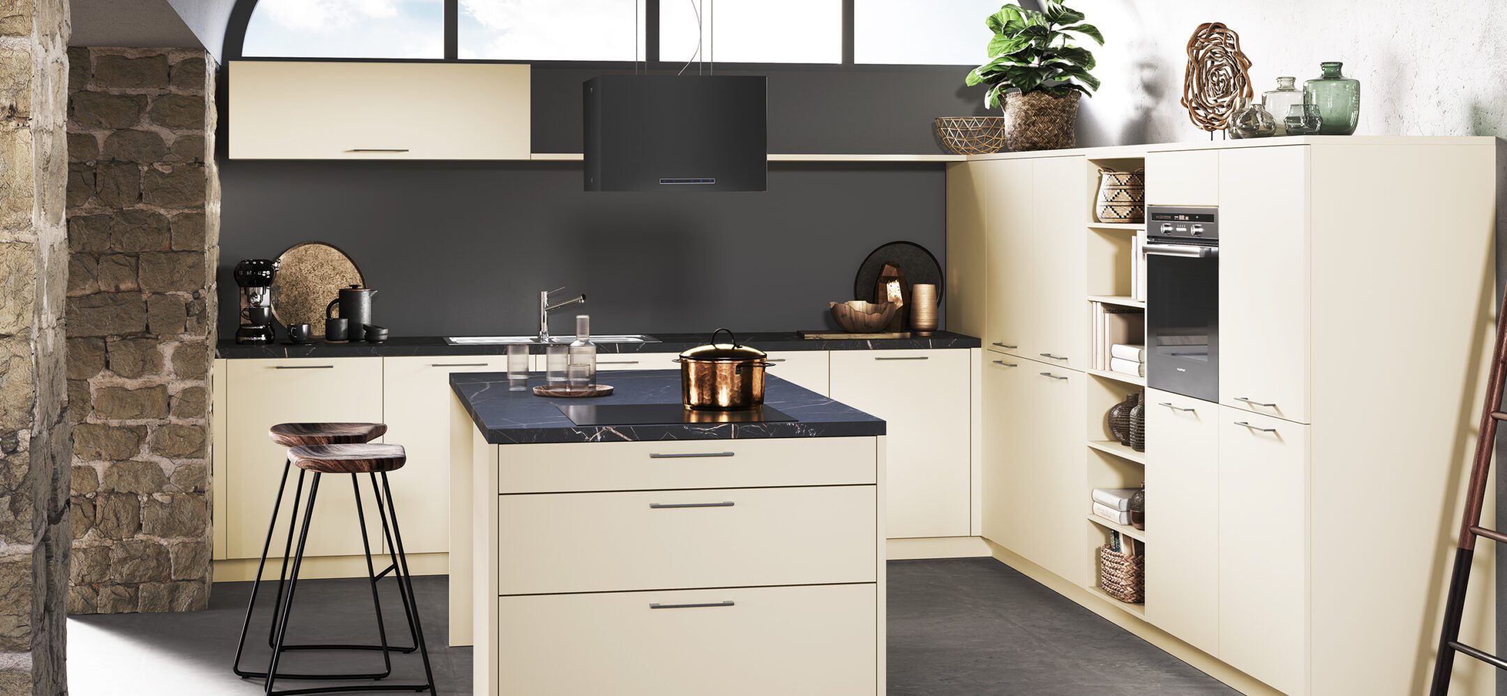 Klassische Inselküche in mattem Beige mit schwarzer Rückwand und dunkler Arbeitsplatte