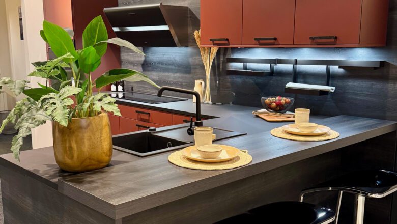 L-Küche mit Arbeitsplatte und Nischenrückwand in Schwarz und Lava