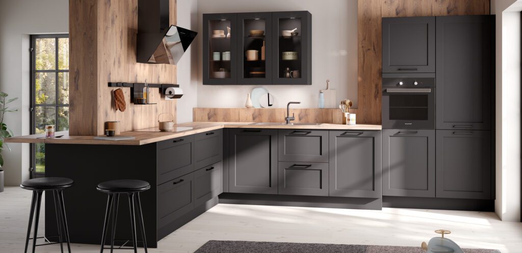 Schwarze Landhausküche in L-Form mit Fronten im Rahmen-Design und Holzdekor-Elementen.