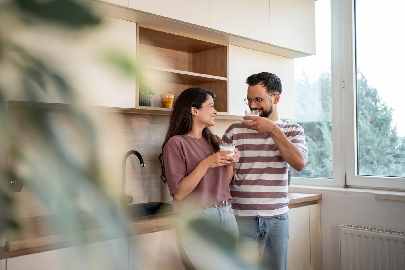 Ein Paar genießt ein Glas Milch in einer modern gestalteten Küche.