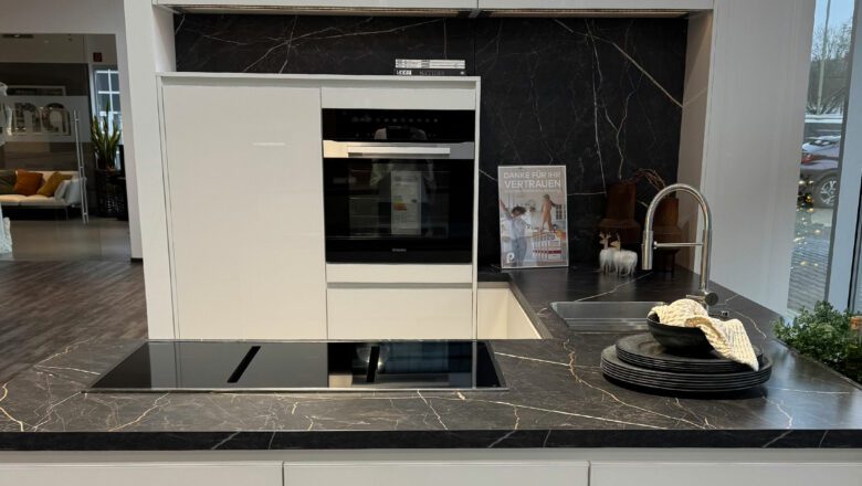 U-Küche mit marmorierter Arbeitsplatte und hochgebautem Backofen