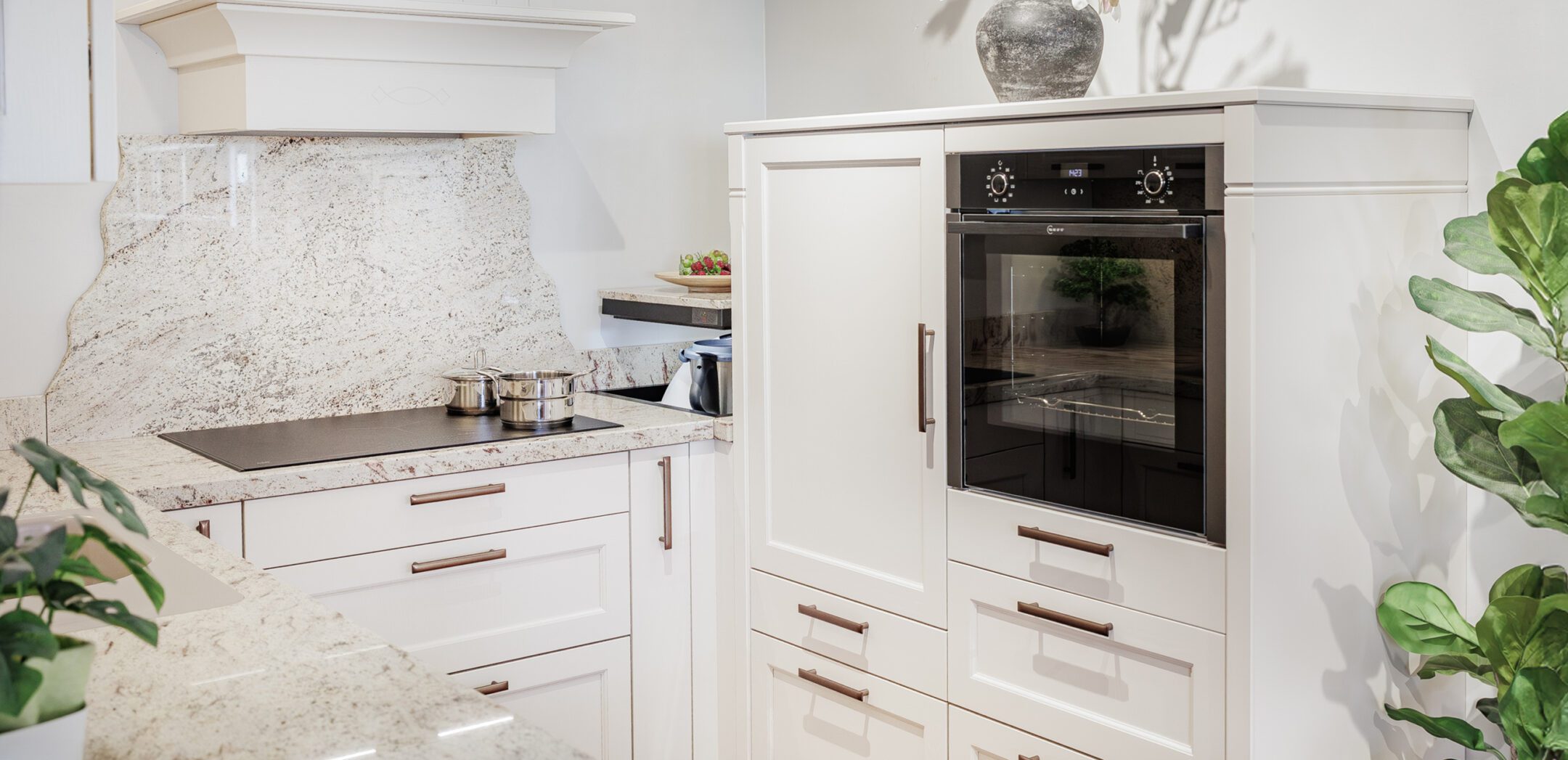 Klassische weiße Landhausküche mit Marmor-Arbeitsplatte und Neff Backofen.