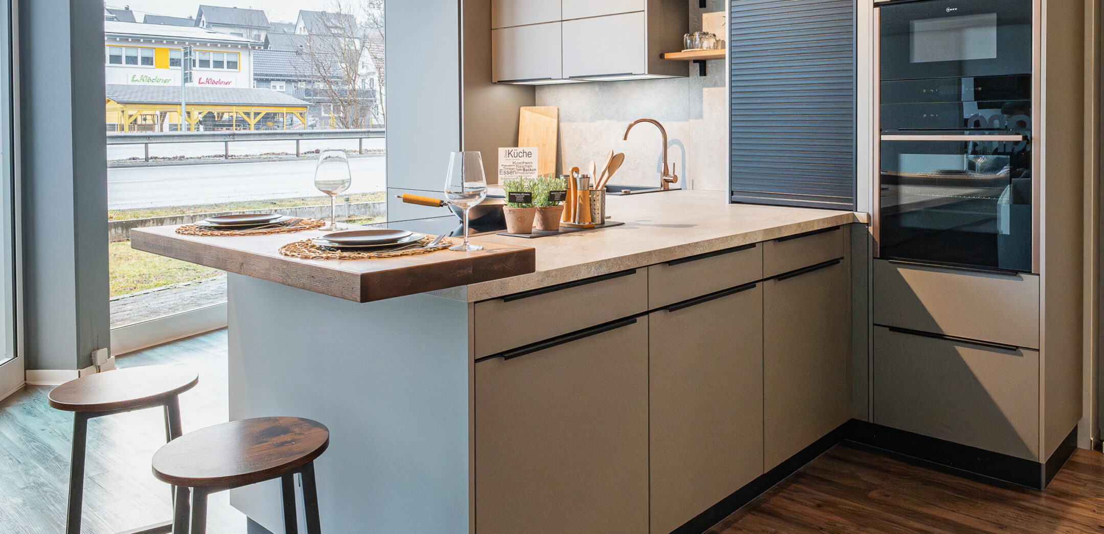 Klassische Küche mit hochgebauten Elektrogeräten und praktischer Sitztheke