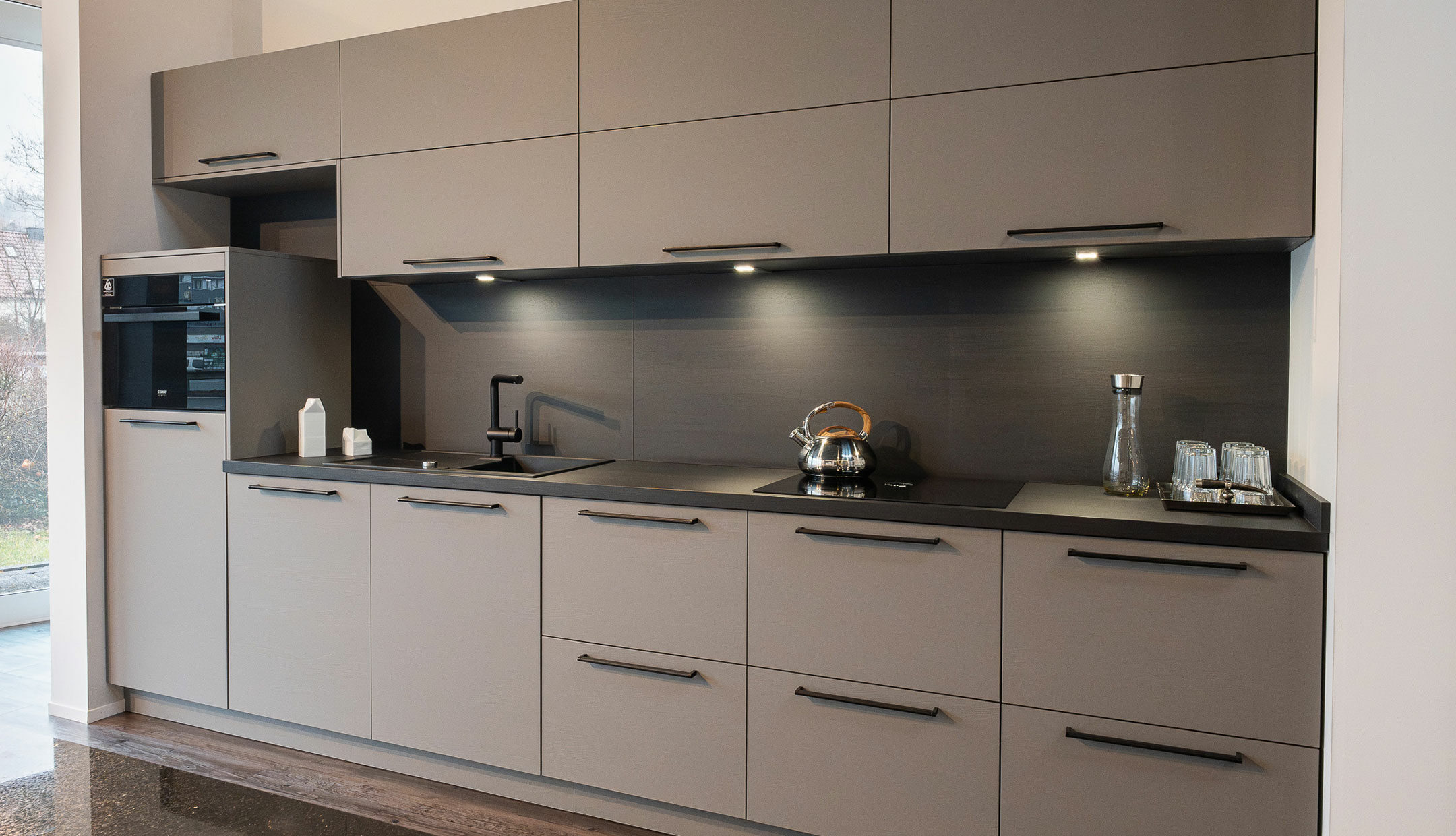 Küchenzeile in klassischem Stil mit breiten Stangengriffen und Fronten in warmen Farbtönen