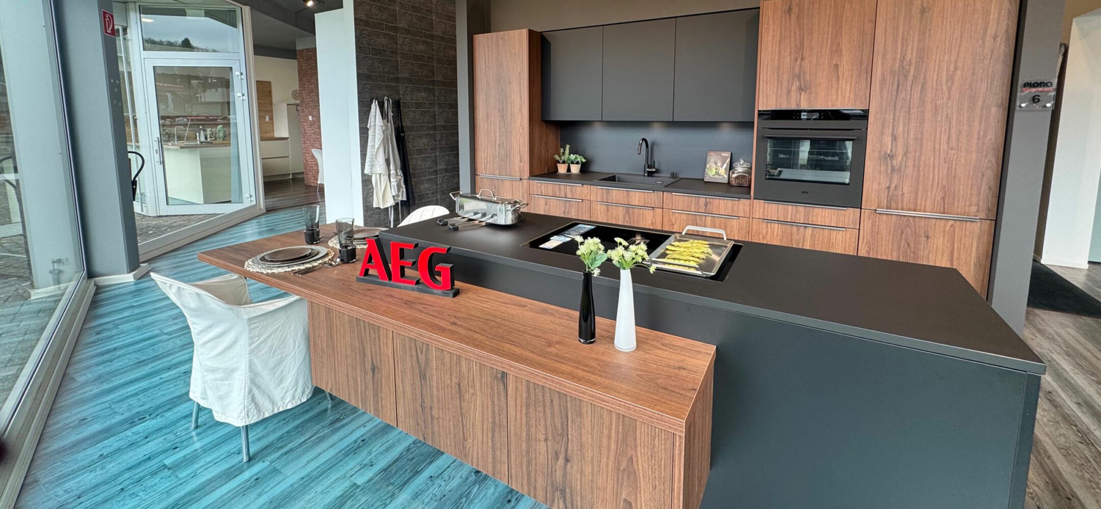 Schöne Inselküche in warmen Farbtönen mit AEG-Geräten