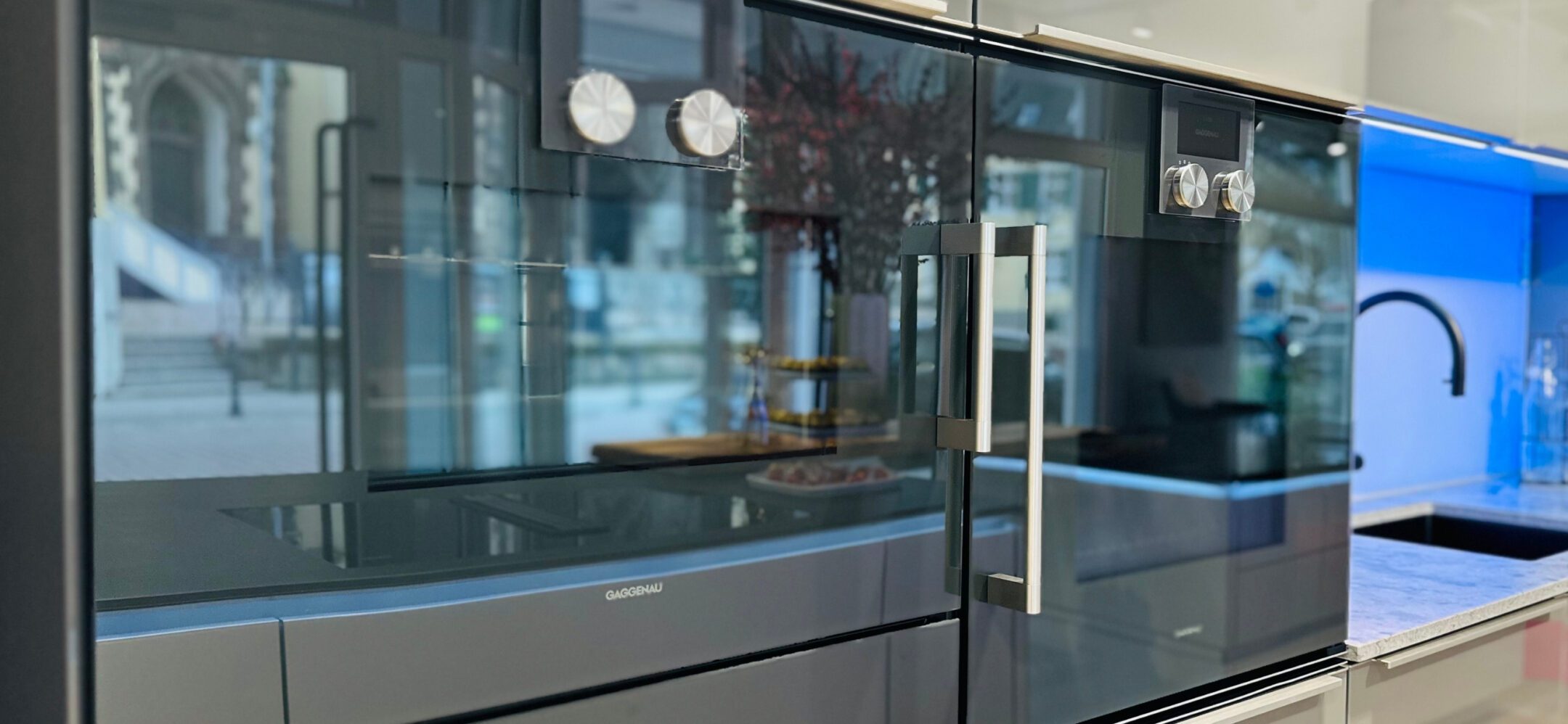 Einbau-Backöfen von Gaggenau mit markanten Edelstahl-Bedienknebeln in einer modernen Küchenausstellung.