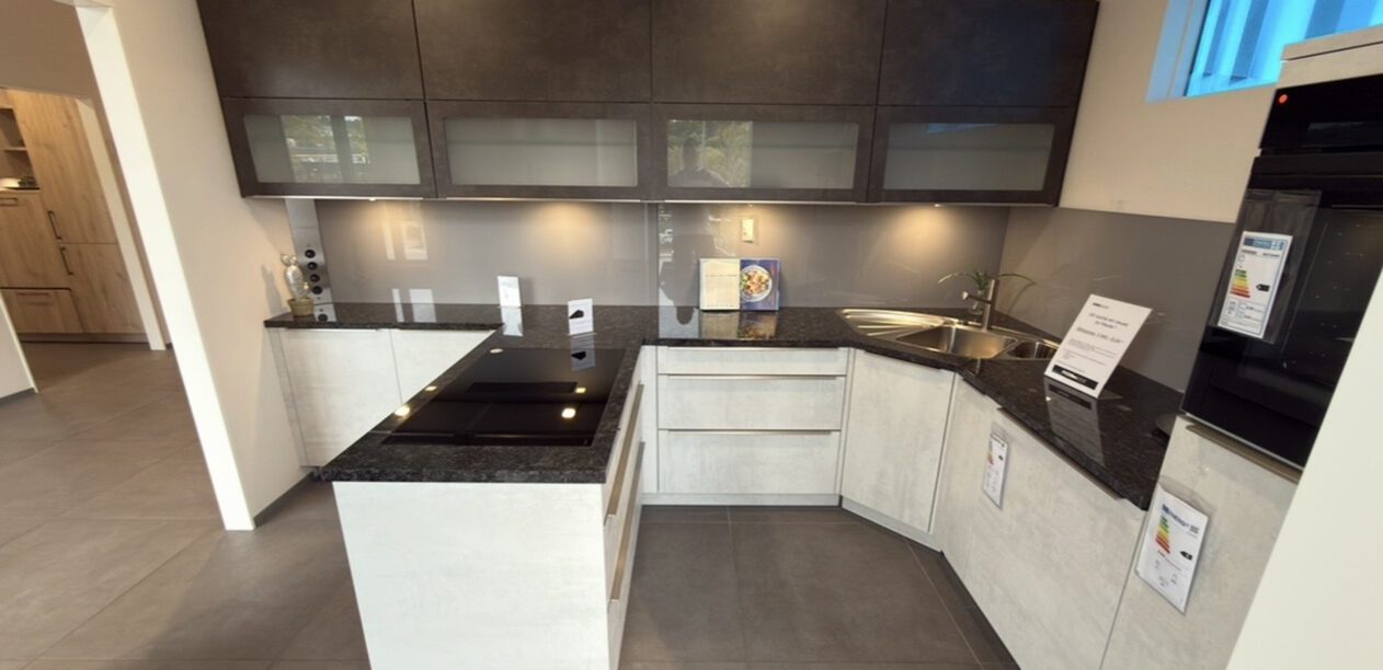 T-Küche mit Arbeitsplatte aus dunklem Naturstein und weißen Fronten