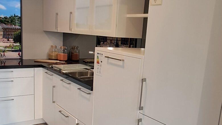 Weiße U-Küche mit schwarzer Naturstein-Arbeitsplatte