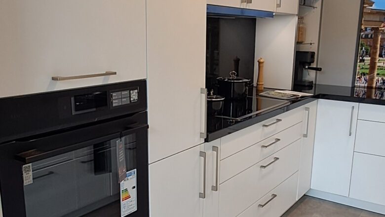 Weiße U-Küche mit breiten Schubladen und breiten Griffen