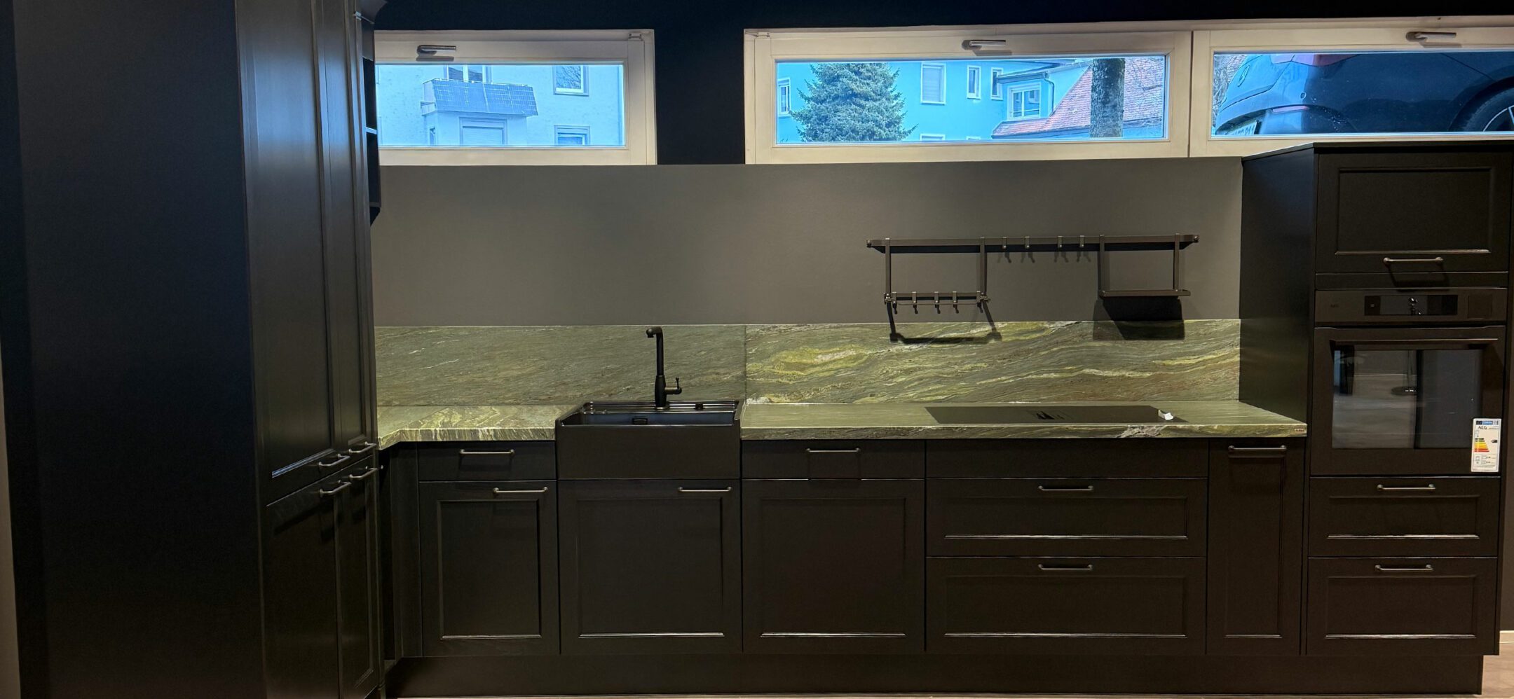 Schwarze Landhausküche mit außergewöhnlicher Nischenrückwand