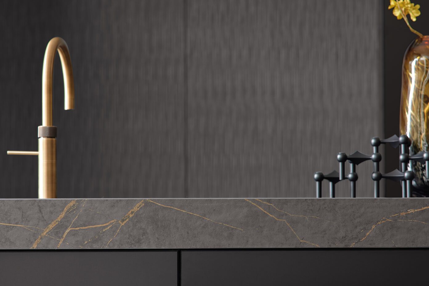 Detailaufnahme einer goldfarbenen Armatur auf marmorierter Arbeitsplatte.