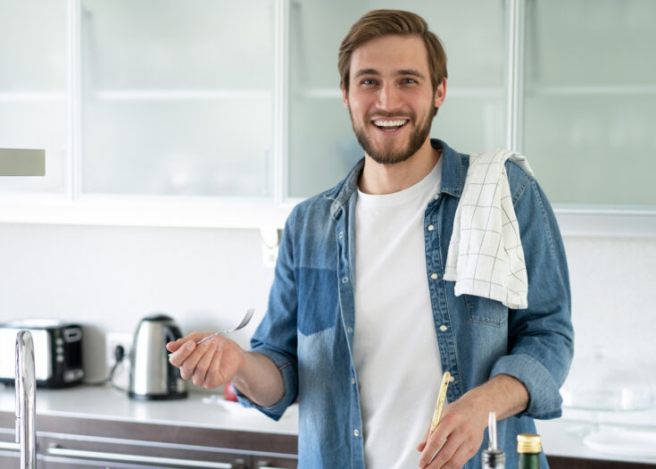 Junger Mann kocht in Küche
