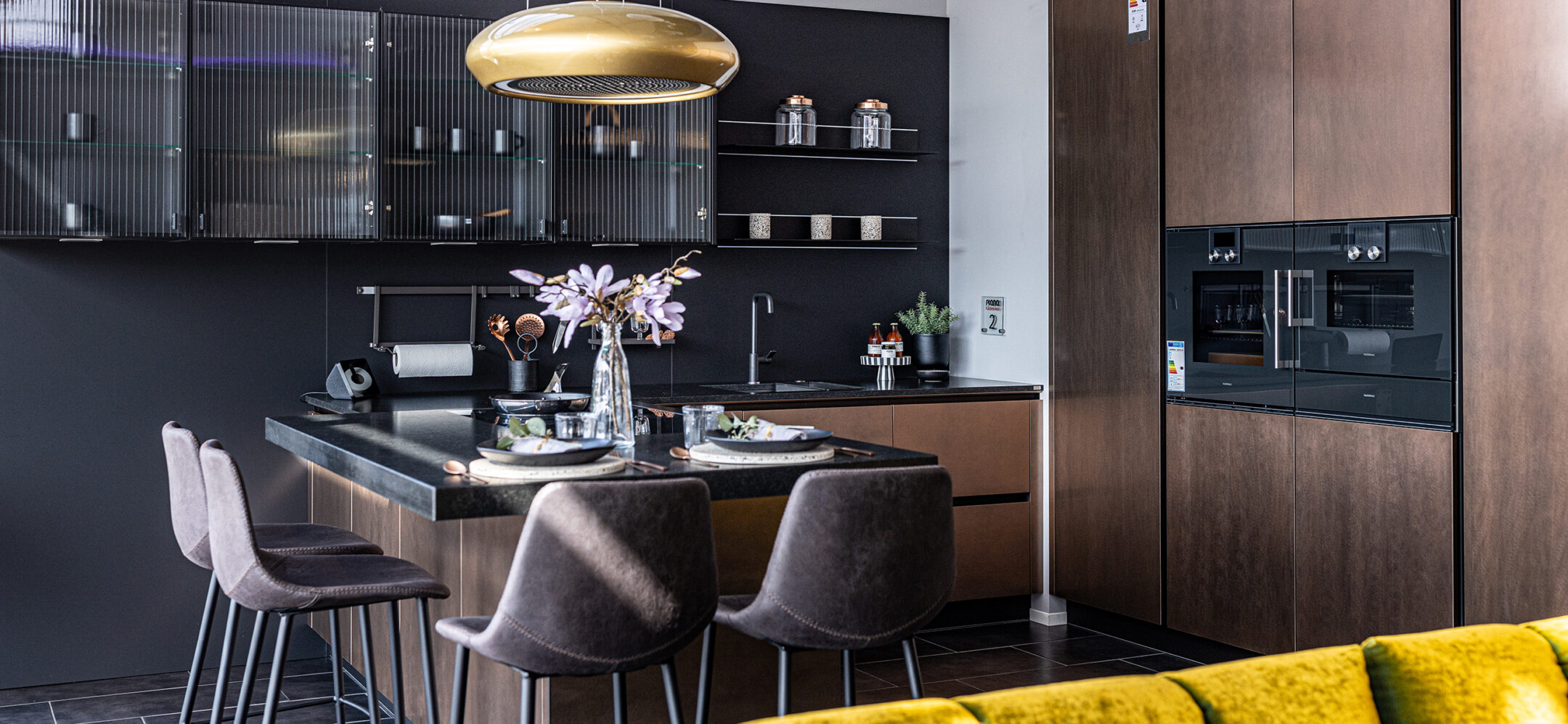 PLANA Küchenstudio Germersheim L-Küche mit rostbraunen Fronten und gemütlicher Sitzgelegenheit
