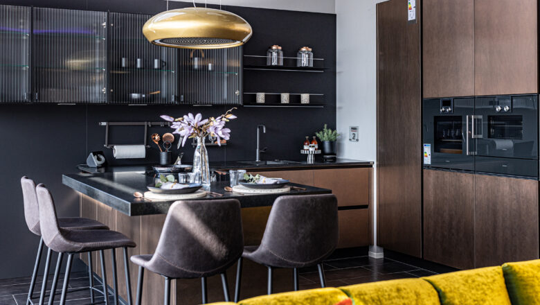 PLANA Germersheim L-Küche mit rostbraunen Fronten und gemütlicher Sitzgelegenheit