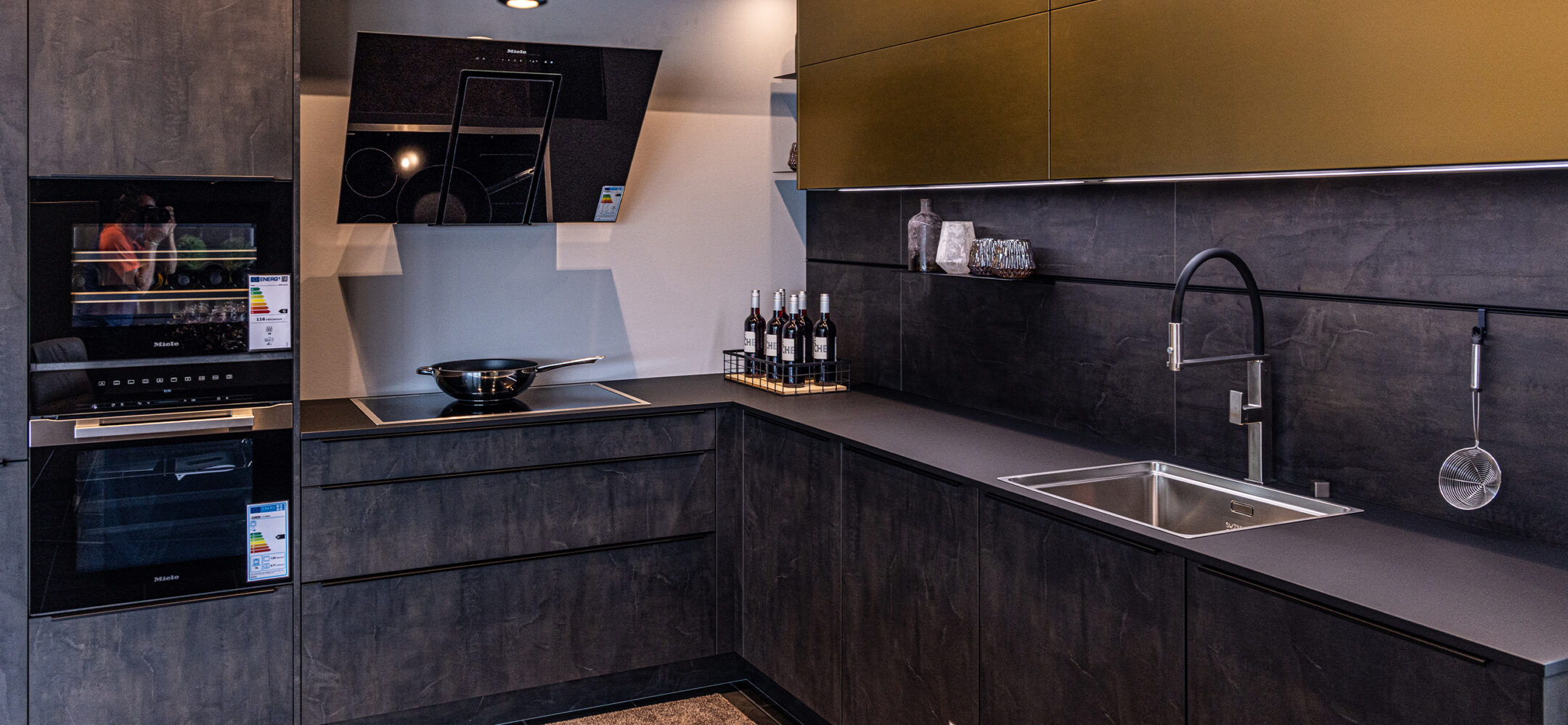 PLANA Küchenstudio Germersheim L-Küche mit dunklen Fronten in Beton-Optik und hochwertigen Einbaugeräten