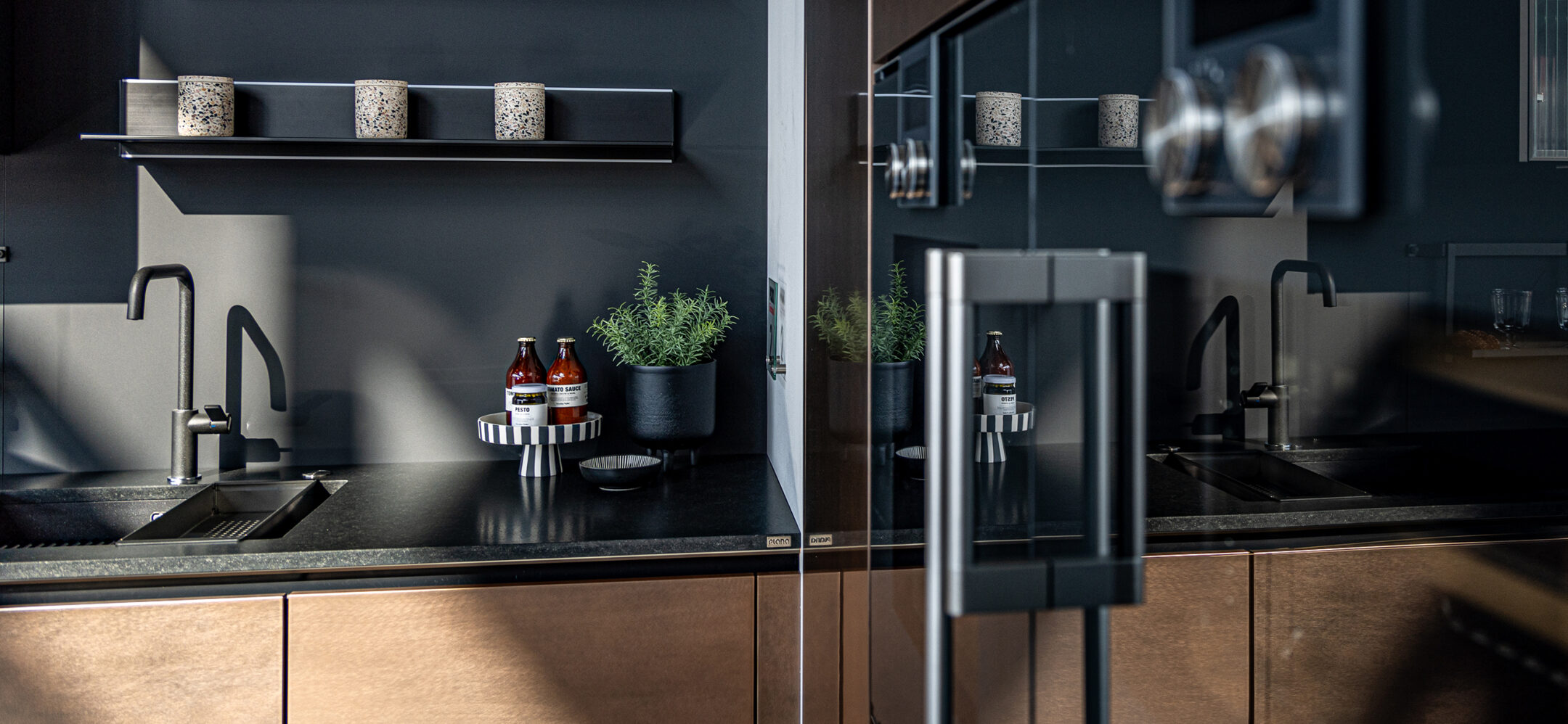 PLANA Küchenstudio Germersheim Küche mit Fronten in Holz-Optik und dunkler Steinarbeitsplatte