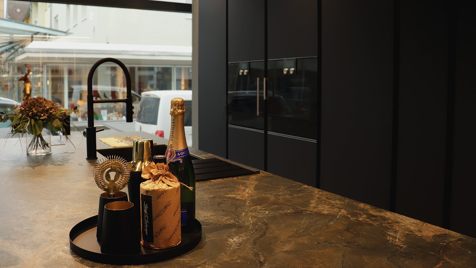 PLANA Küchenausstellung Heilbronn moderne Inselküche mit mattschwarzen Fronten und hochwertiger Steinarbeitsplatte