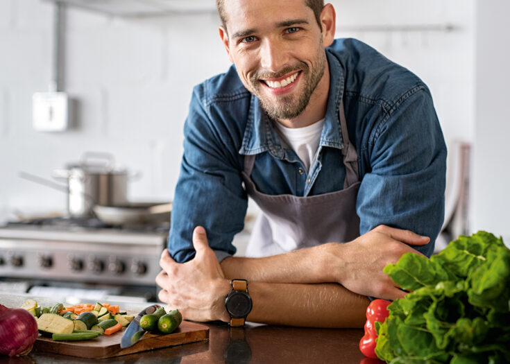 Mann lehnt zufrieden auf seiner Arbeitsplatte