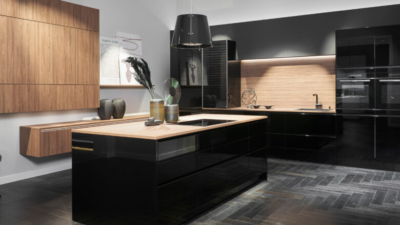 Inselküche mit schwarzglänzender Front und Arbeitsplatte in Holzoptik