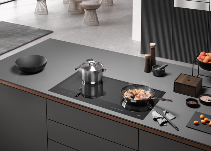 Graue Design-Küche mit hochwertigem Kochfeld von Miele