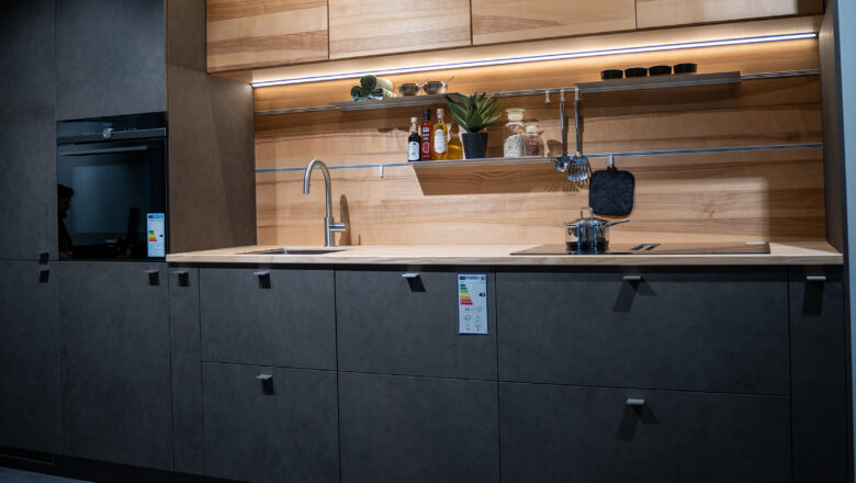 Kleine Küchenzeile mit dunklen Fronten und Holzarbeitsplatte und Holznischenrückwand