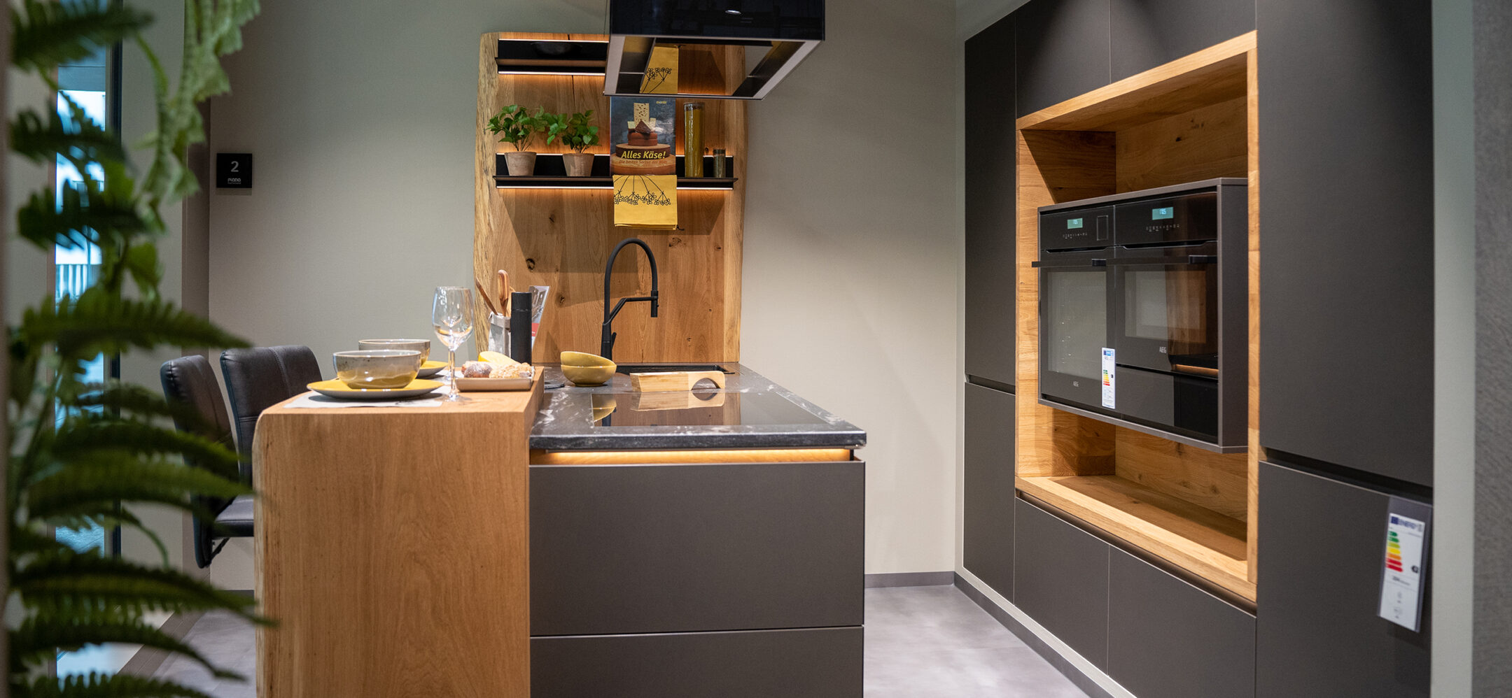 Grifflose Inselküche mit Fronten in Holt und matt schwarz und einer Granitarbeitsplatte