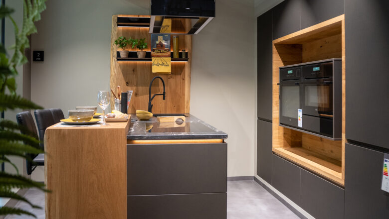 Grifflose Inselküche mit Fronten in Holt und matt schwarz und einer Granitarbeitsplatte