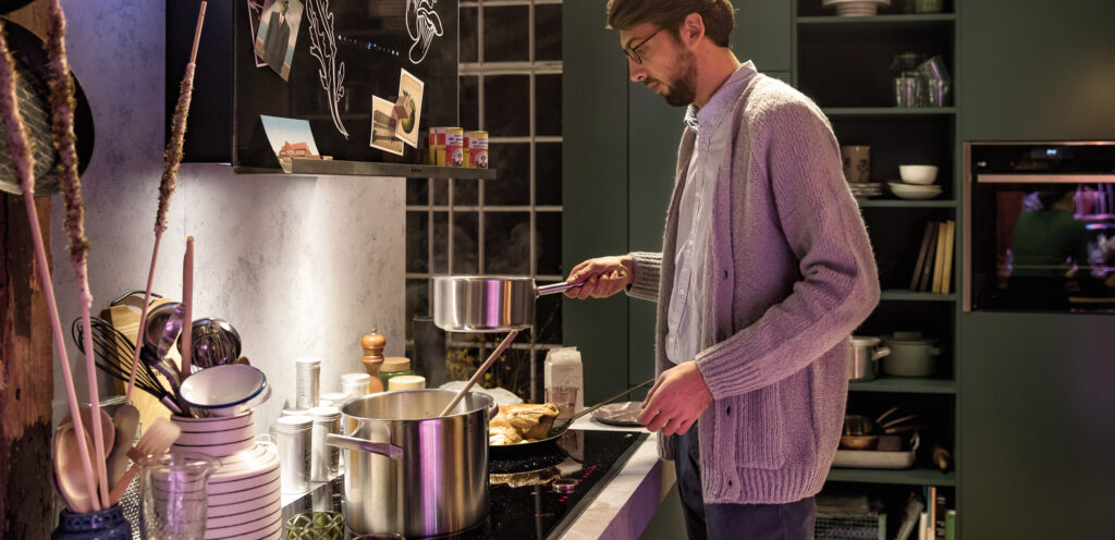 Junger Mann beim Kochen in seiner Single-Küche