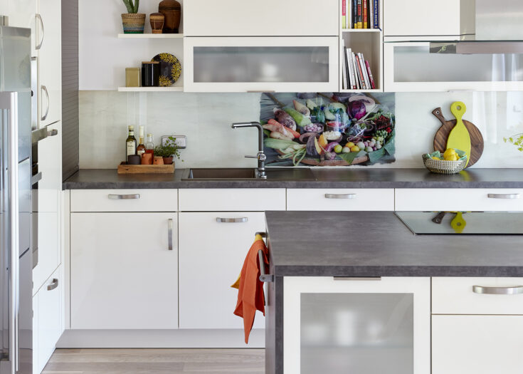 Küche im Klassik-Stil mit farbiger Arbeitsplatte und Glas-Nischenrückwand
