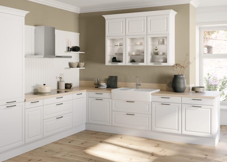 Weiße Landhausküche in L-Form mit großem Keramik-Waschbecken