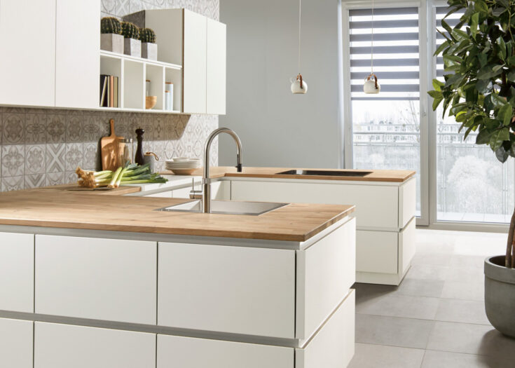 Weiße Grifflosküche mit Holzarbeitsplatte in U-Form