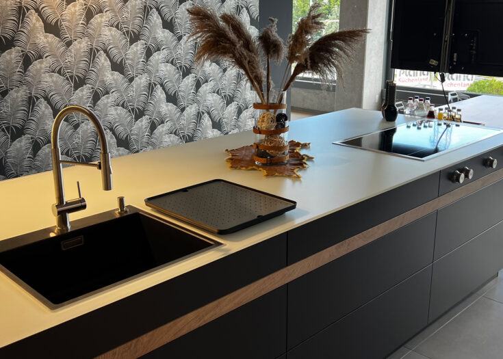 Ausstellungsküche in Inselform mit grifflosen Fronten und hochwertiger Ausstattung