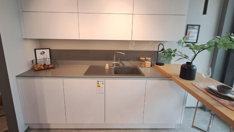 Weiße grifflose Küchenzeile einer Inselküche mit Holztheke