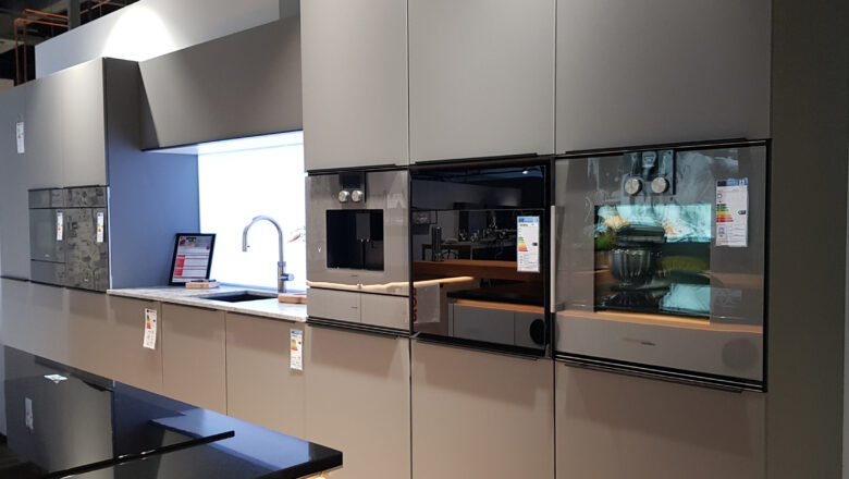 Einzeilige Küche mit grauen Glas-Fronten und Elementstein-Arbeitsplatte