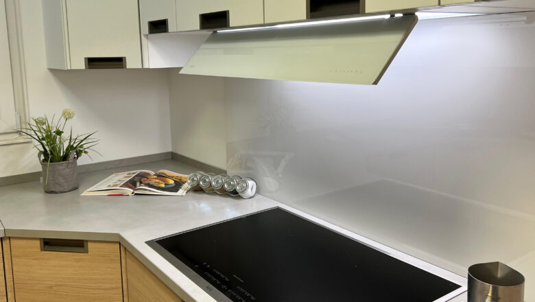 Musterküche mit weißer Glas-Nischenrückwand