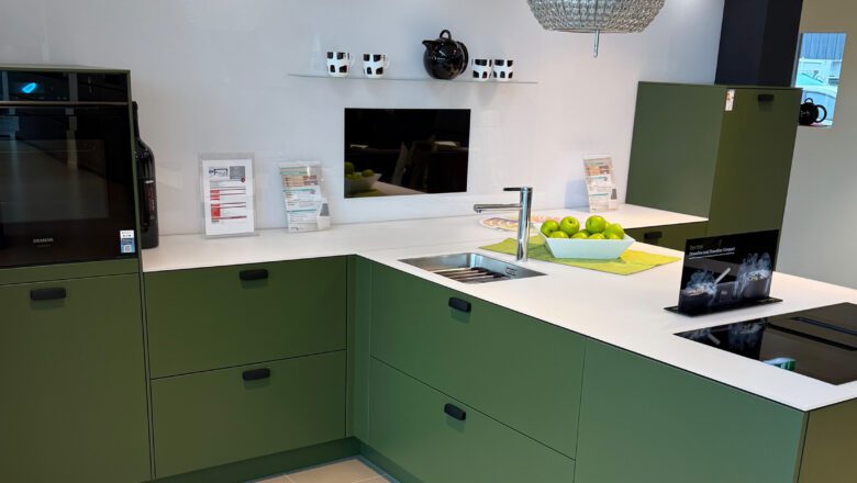 PLANA Küchenausstellung Hilden Olivgrüne Küche in T-Form mit weißer Glas-Arbeitsplatte