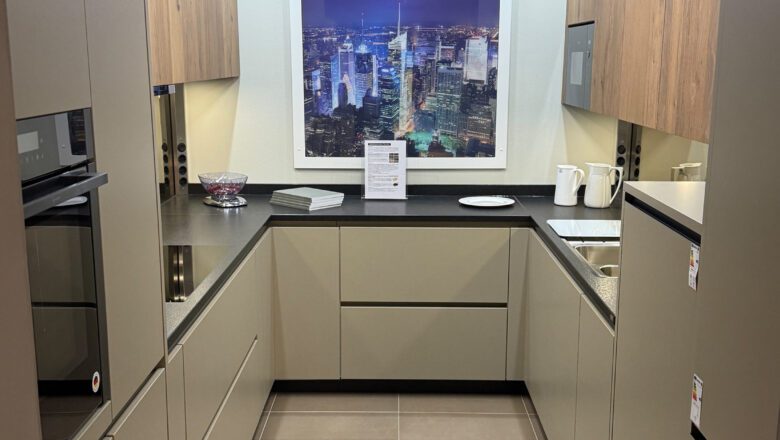 PLANA Küchenausstellung Hilden Grifflose U-Küche mit schwarzer Naturstein-Arbeitsplatte