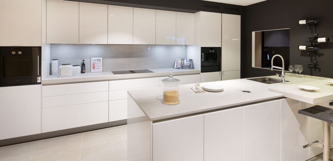 Hochwertige Inselküche mit kristallweißen Glanzlackfronten
