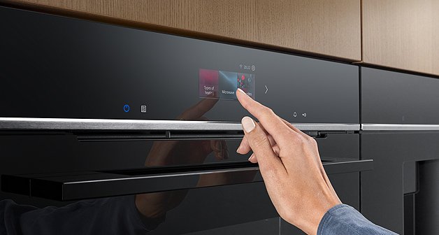 Frauenhand bedient Touchdisplay am Siemens Backofen