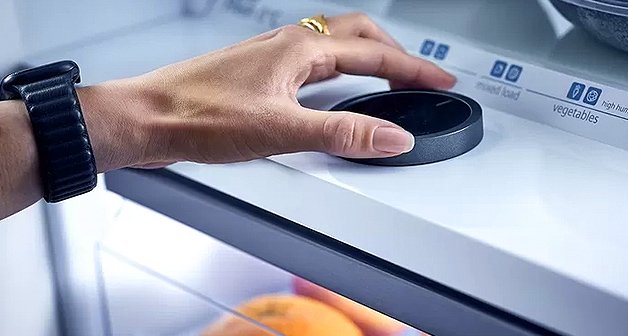 Hand dreht am Kühlschrank-Temperaturregler