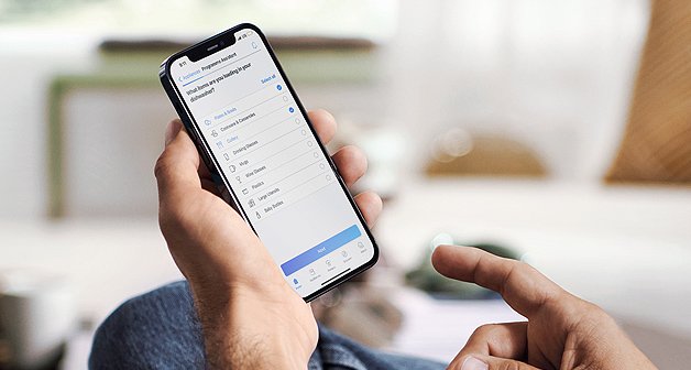 Hand mit Smartphone und Siemens App zur Steuerung der Haushaltsgeräte