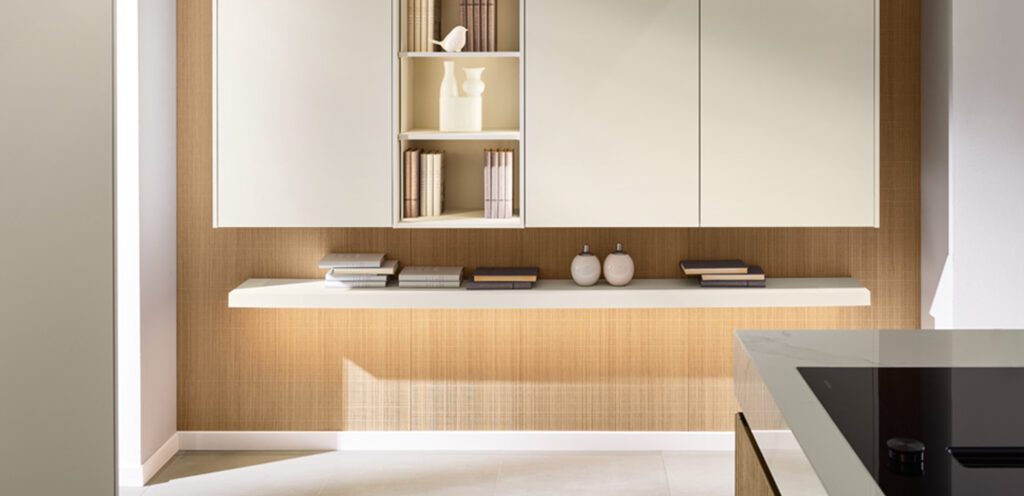 Weiße Küchenschränke in Wohnraum integriert mit Regalbrett für Bücher